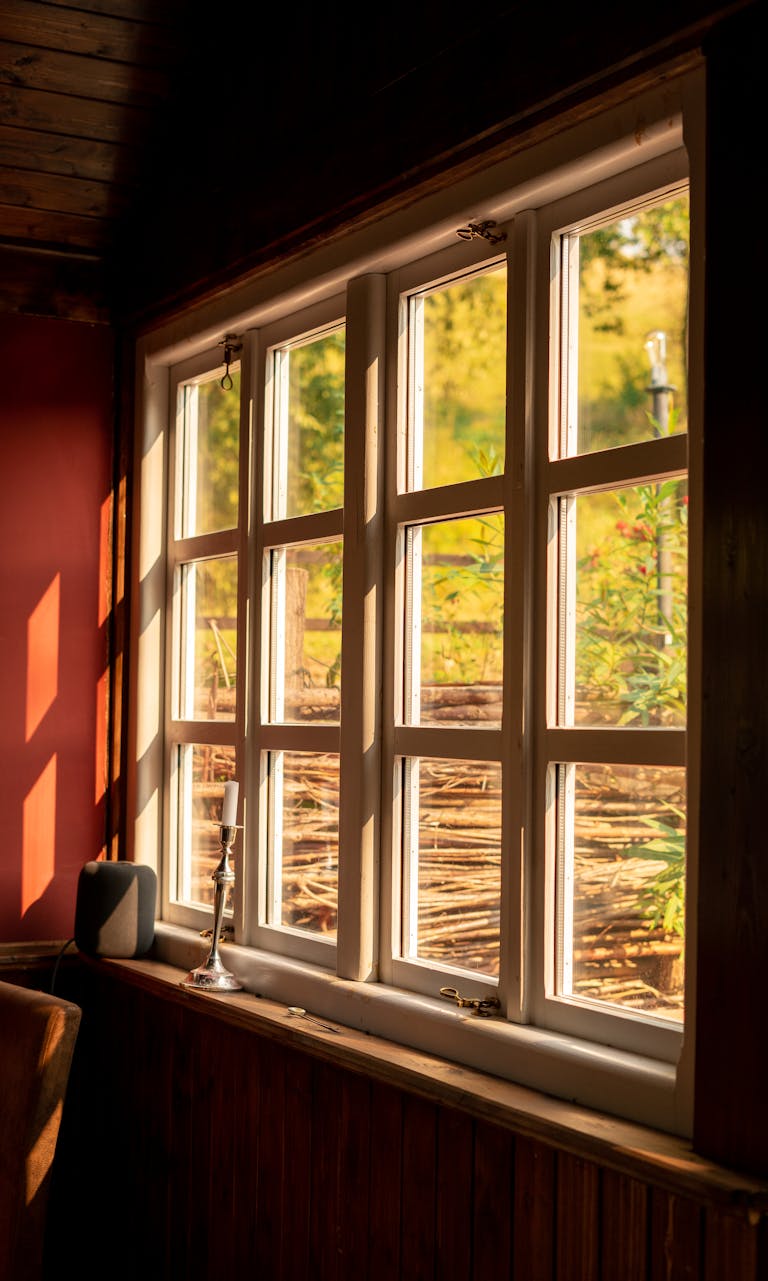 Sunlight streaming through a cozy wooden window, casting soft shadows indoors.